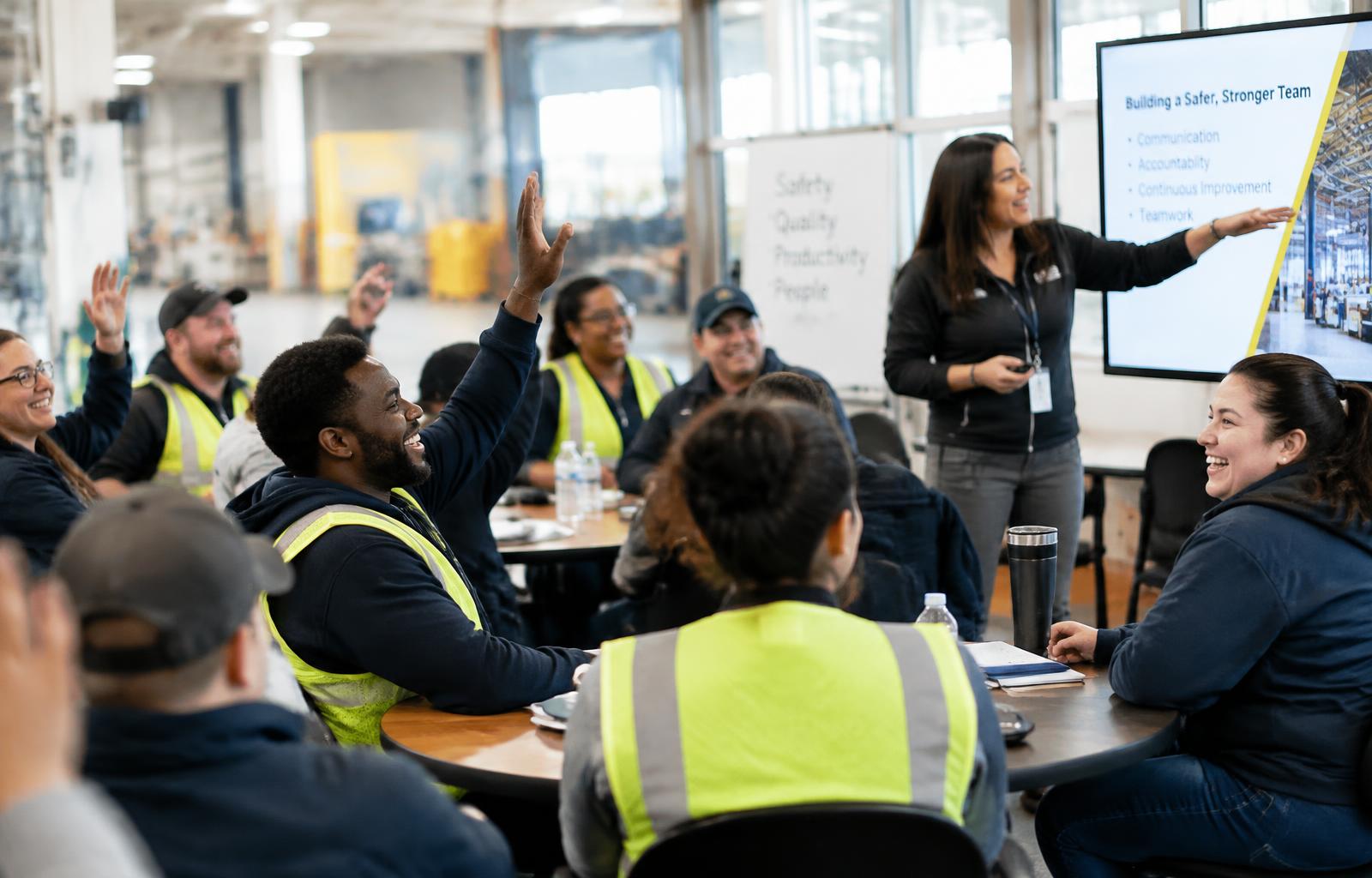 Engaged frontline employees raising their hands during an interactive ATR training session